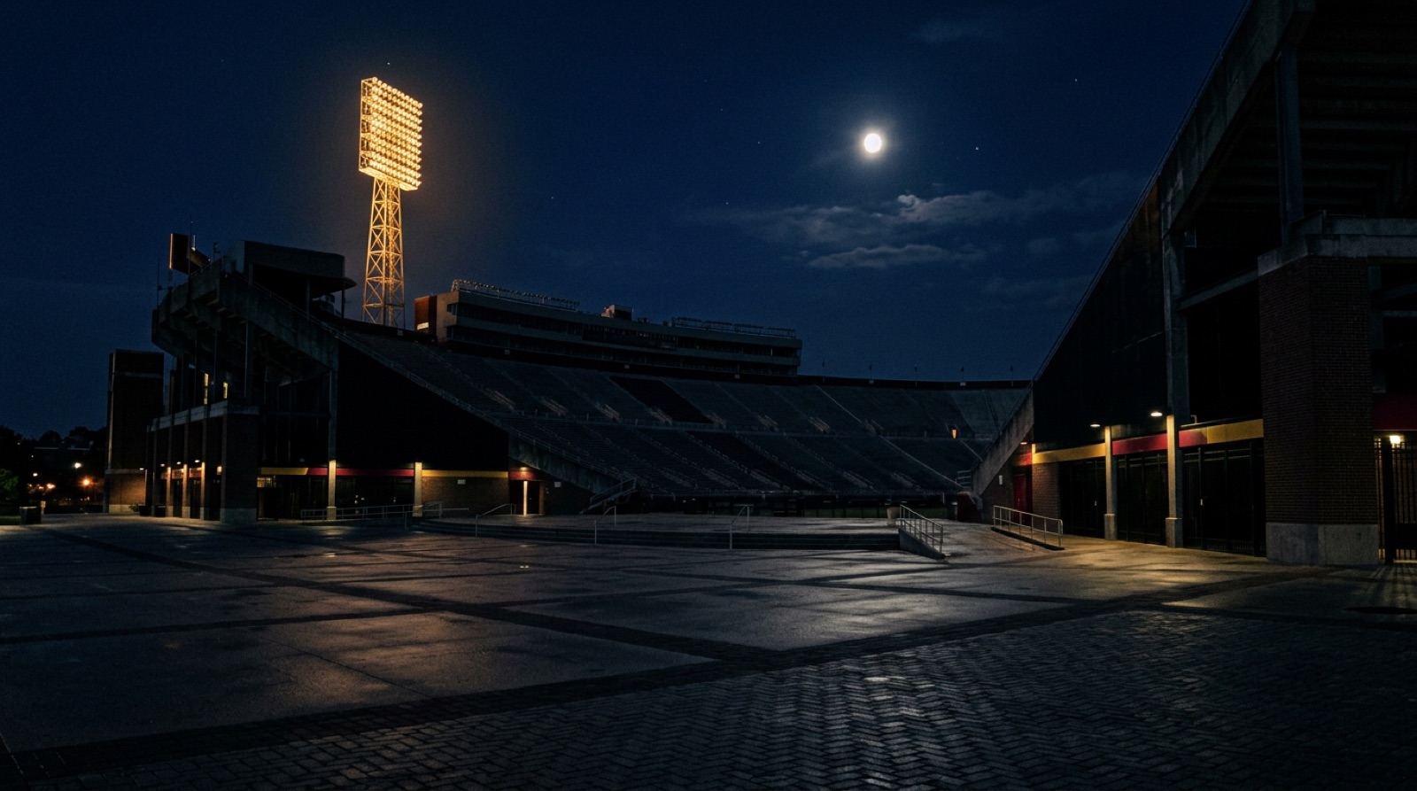 Stadio di notte con luna e ultima torre faro accesa